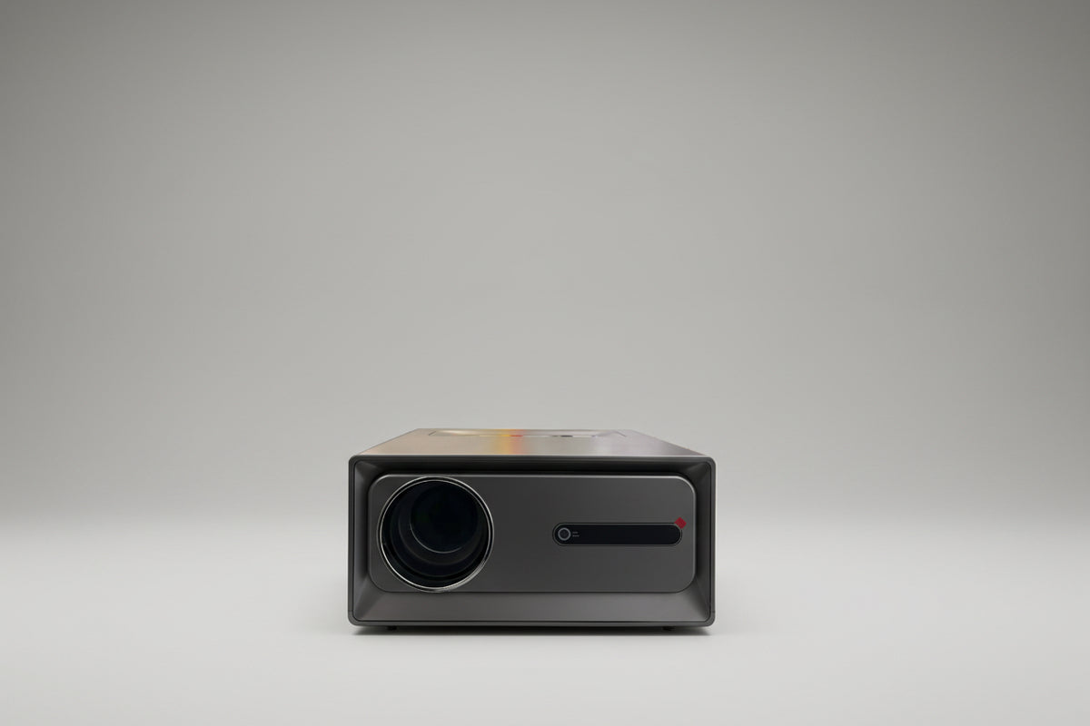 A projector placed on a surface with natural light casting a shadow on its screen.