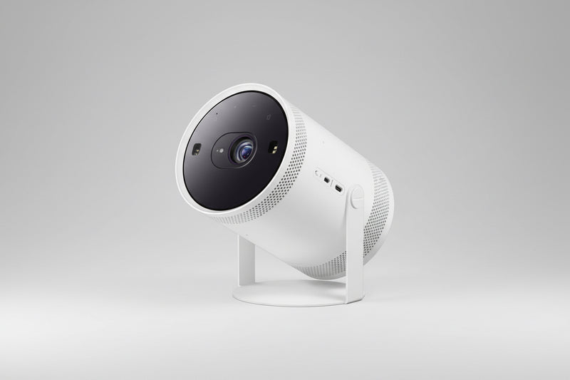 A white Samsung Freestyle Full HD Projector on a stand, displaying the lens and speaker grills on the front.
